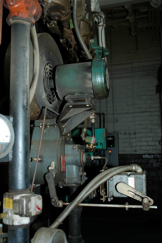 green and gray mechanical machine beside wall